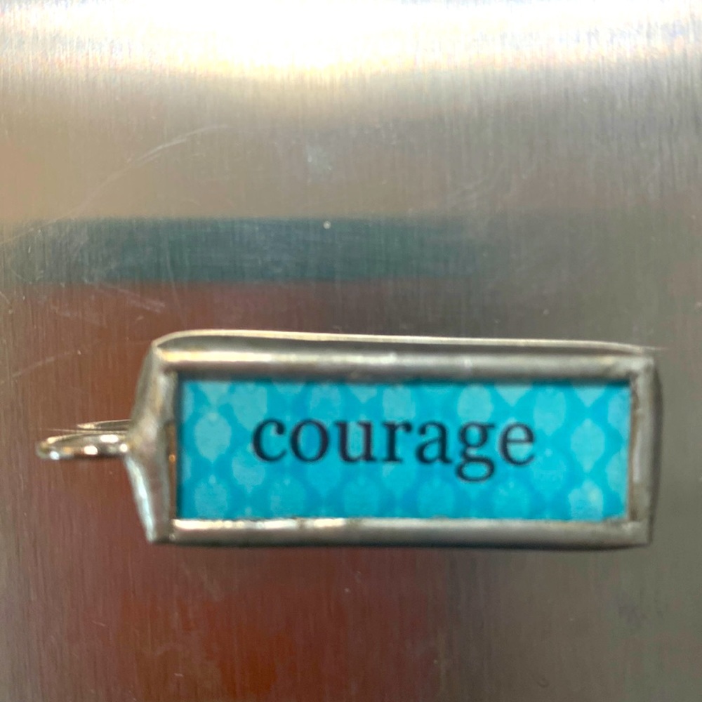 NWOT Fashion charm “Courage” blue background. Measures 1.5 inch
